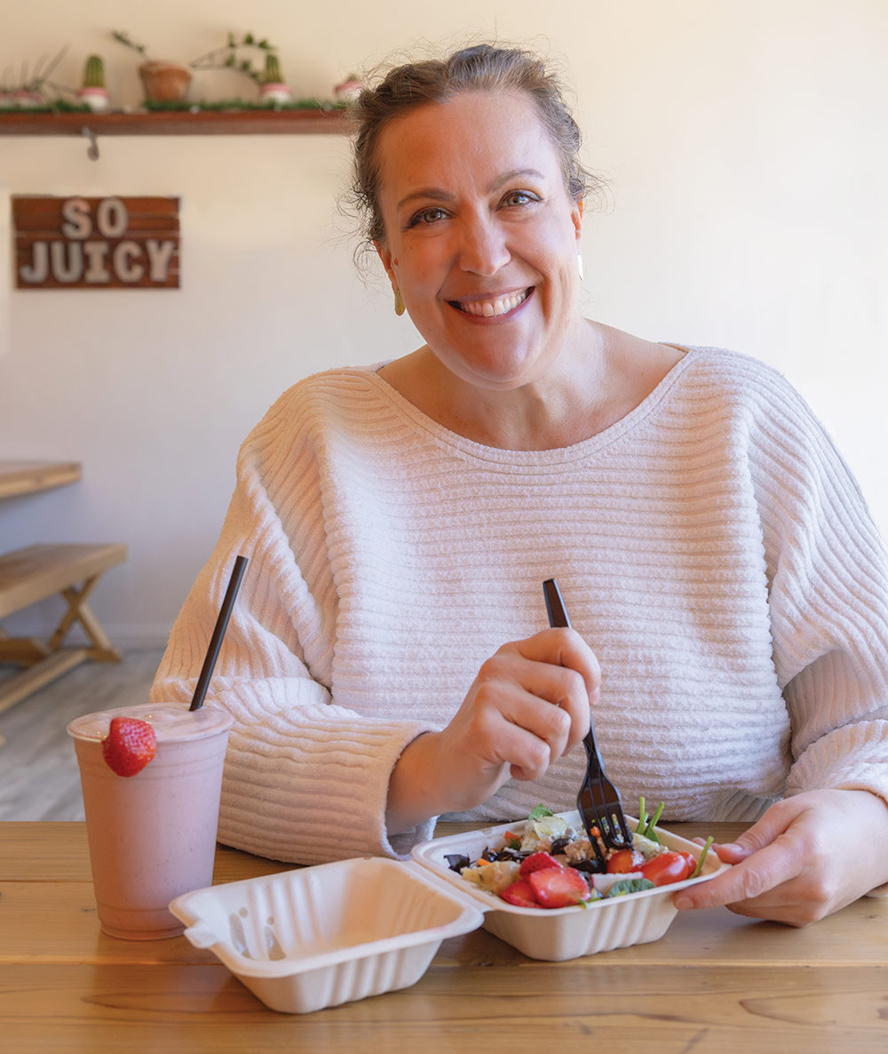 Susan Mowers (author) sits at a table in So Juicy restaurant in Carson City. She has a salad and smoothie in front of her
