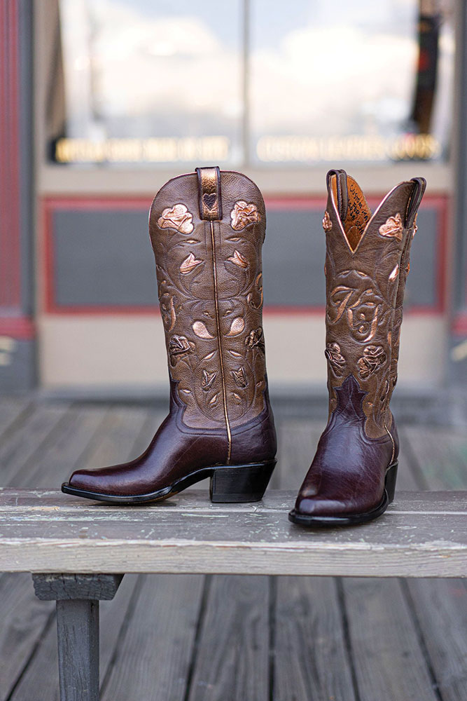 Houston Boot Company, a pair of stylized western boots on a wooden bench.