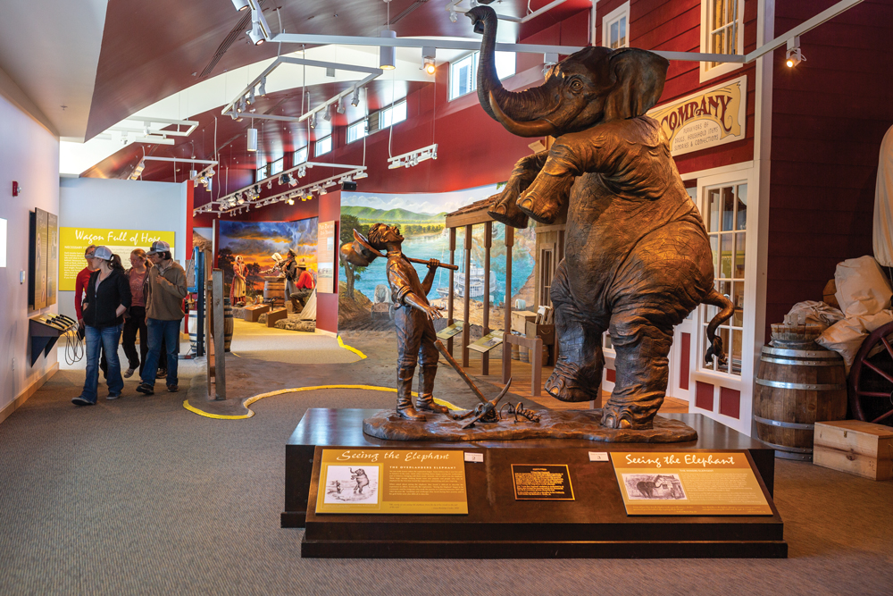 Statue of a miner staring up at an elephant inside the California Trail Interpretive Center. 