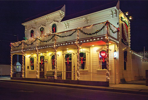 The outside of J.T. Basque Bar & Dining Room, at night. Lit up and decorated for Christmas.