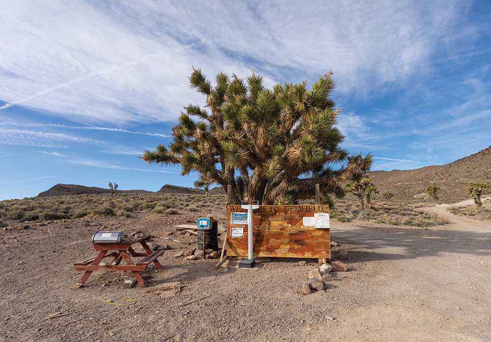 The entry point to Gemfield, with a picnic table, scale, and information posted to a board.