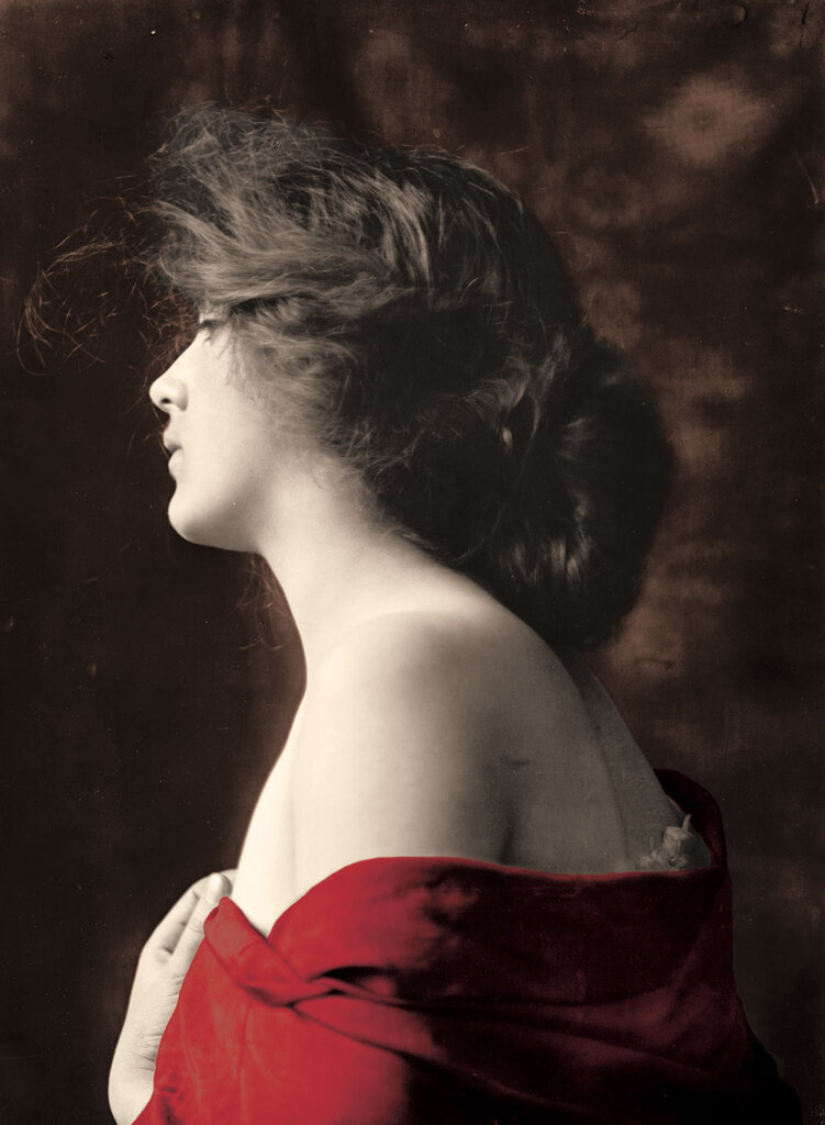 Woman wrapped in a red shawl, facing left in profile, with voluminous hair, against a dark, textured background.