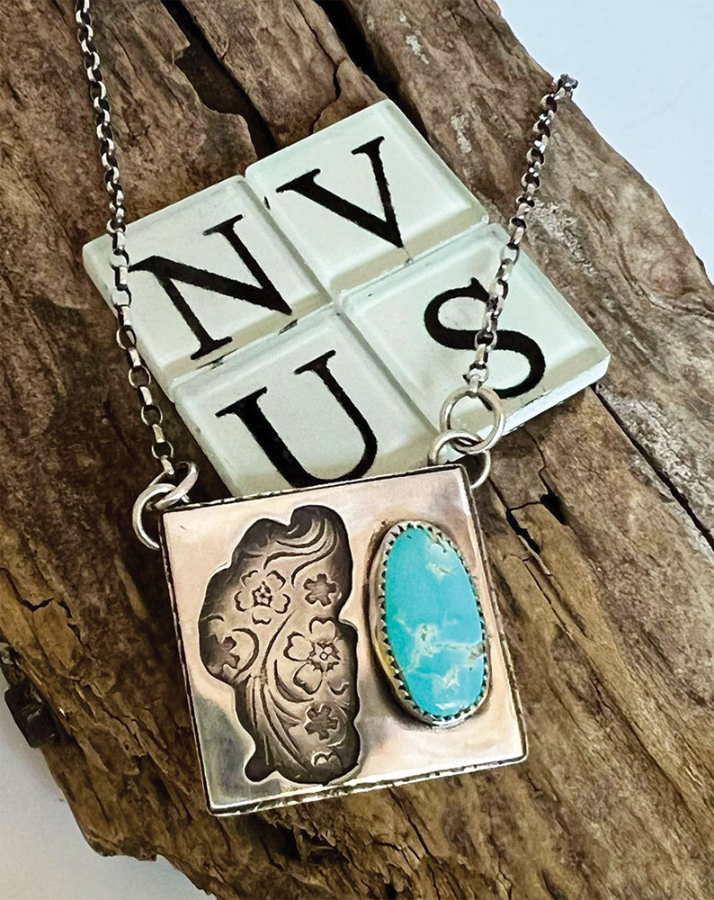 NV-US Silver Works silver and turquiose Lake Tahoe necklace on a piece of wood.