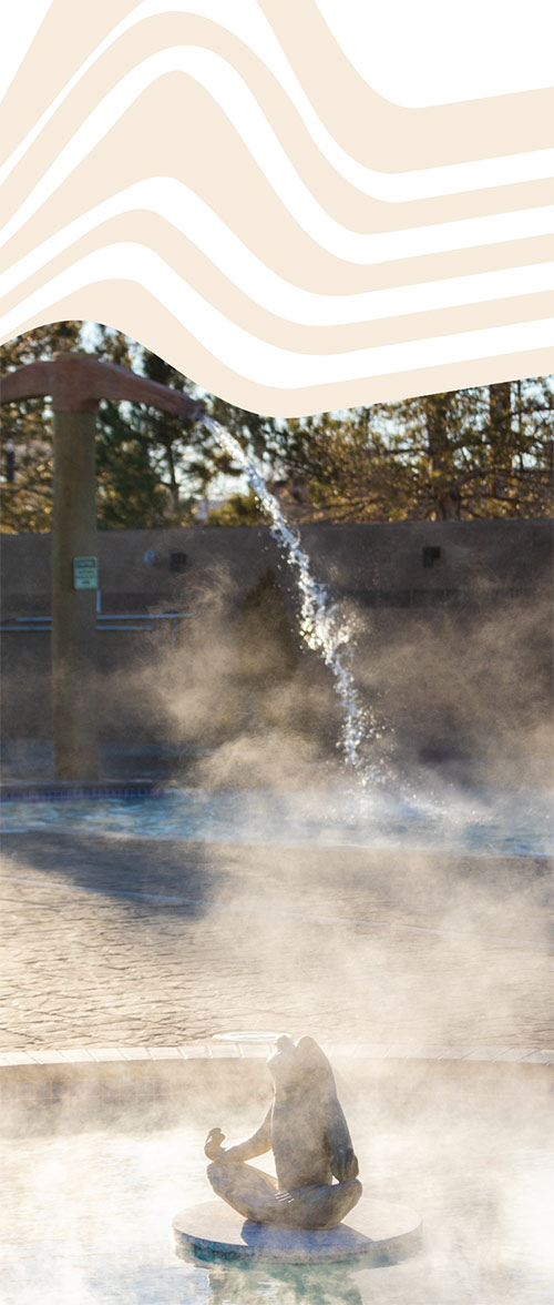Steamy pools, separated by a cobblestone type surface. There is a frog statue in the front pond, and water falling from a large prospector pick into the second pool.