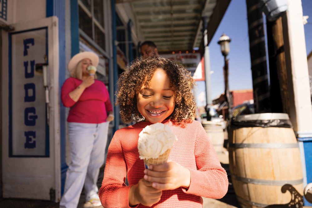 Child holding an ice cream cone outside Grandma's Fudge Factory.