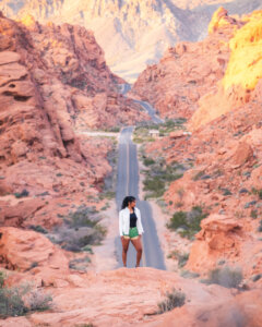 Girl standing on a rock above a road in Valley of Fire.