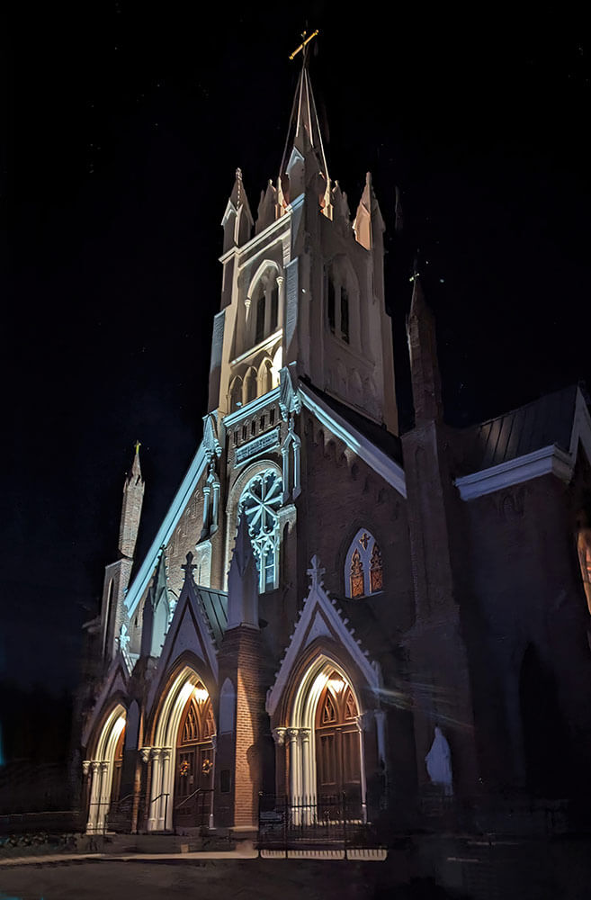 A historic church lit up at night.