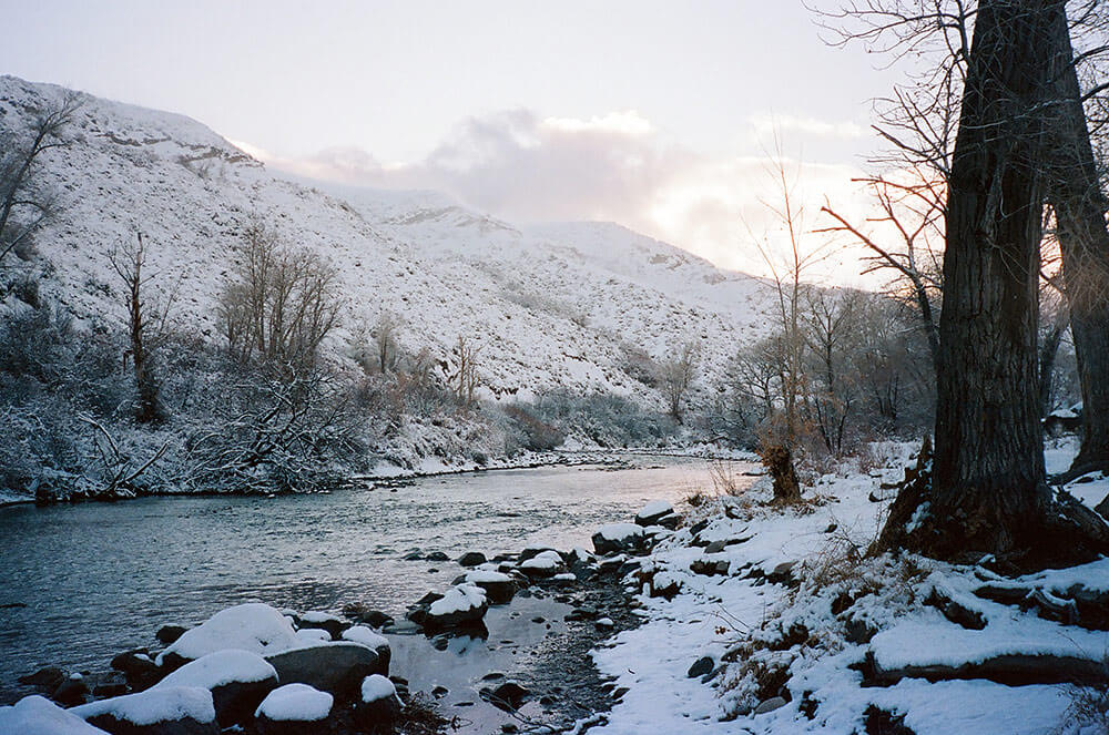 Snowy river scene, with gray cloudy skies.