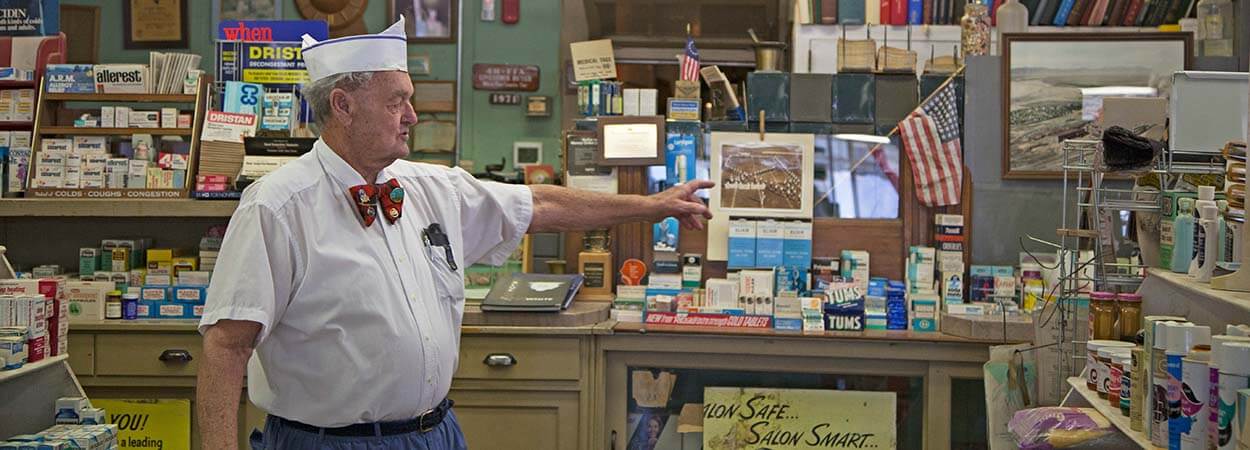 a tour guide shows a display at the mcgill drugstore museum
