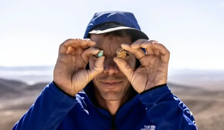 alex honnold posing with turquoise rocks in front of his eyes