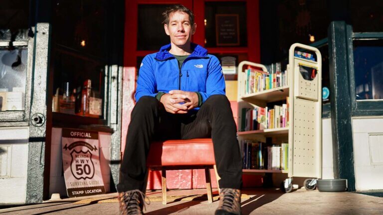 alex honnold posing in front of nevada business off of highway 50
