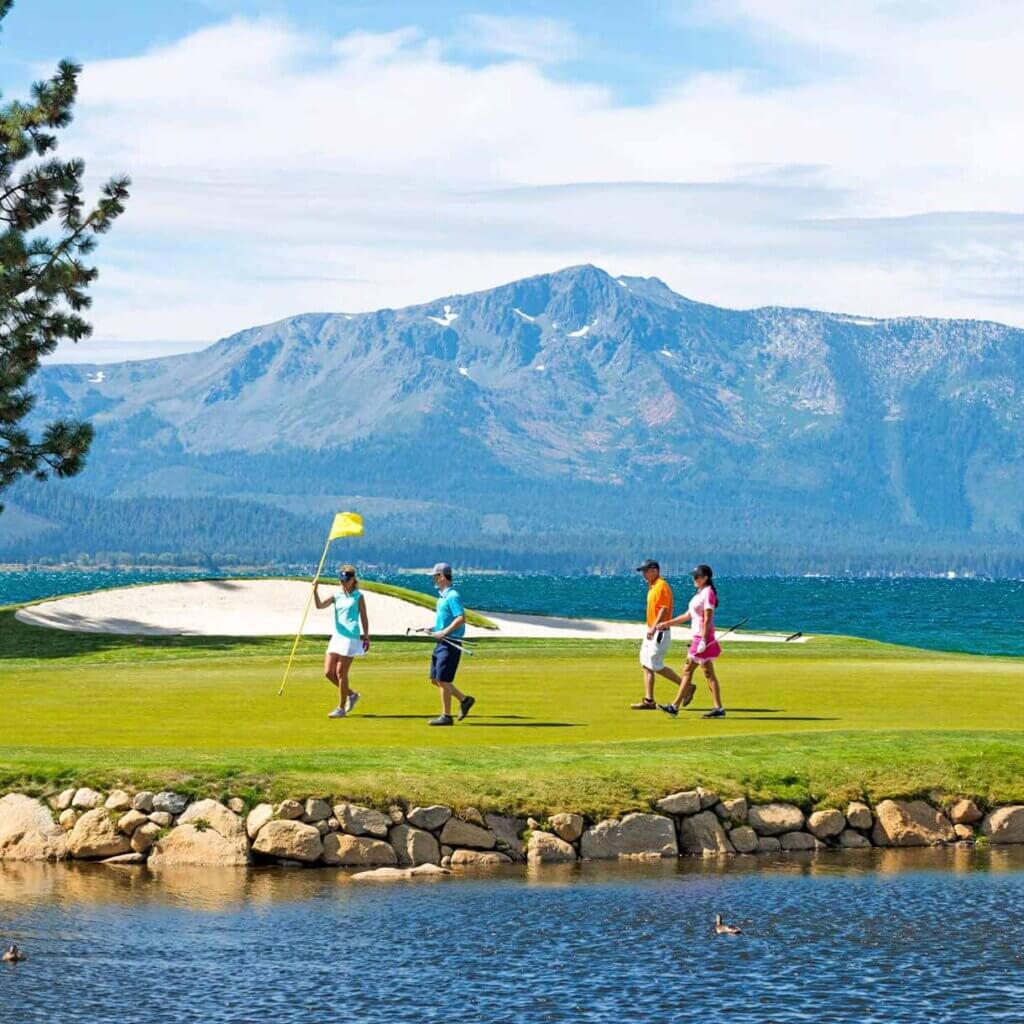golfers pulling the pin at one of the best golf courses nevada with lake tahoe in the background