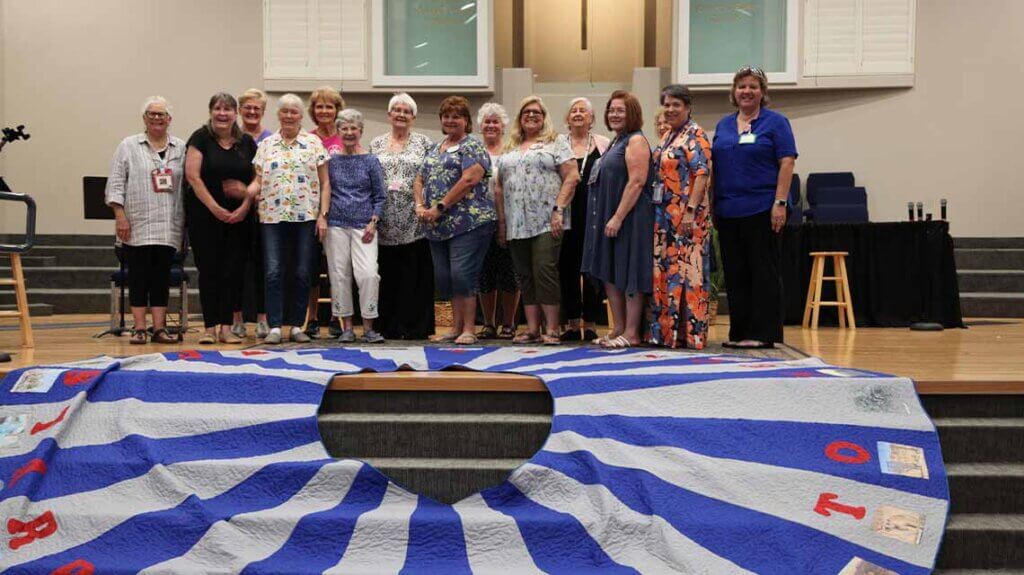 group posing by quilted tree skirt