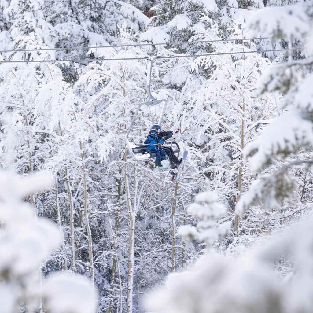 skiiers on chair lift at lee canyon ski resort