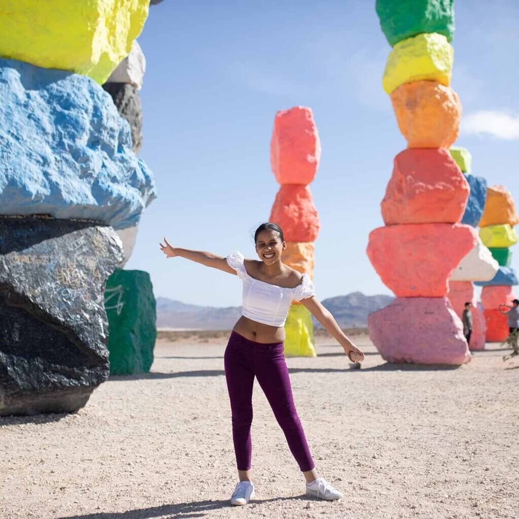 woman posing by seven magic mountains art in southern nevada