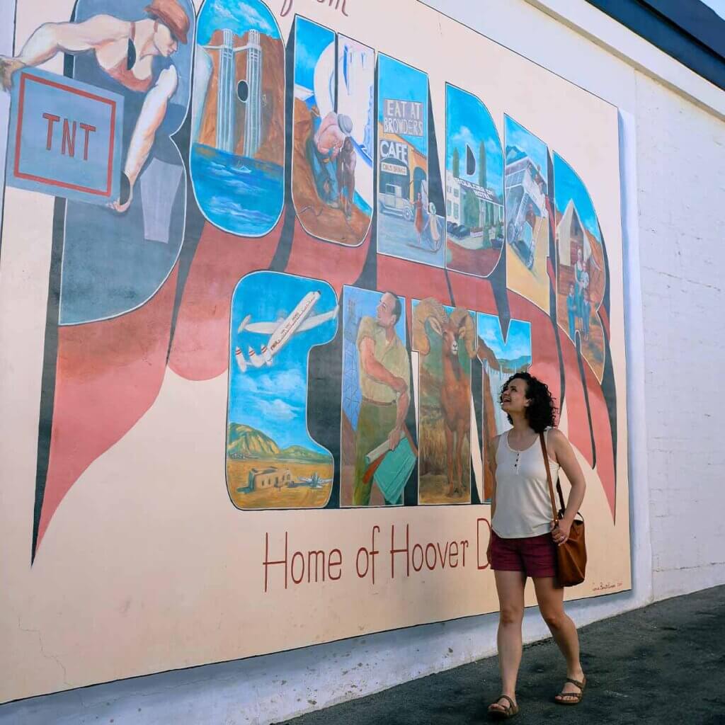 woman walking by boulder city mural