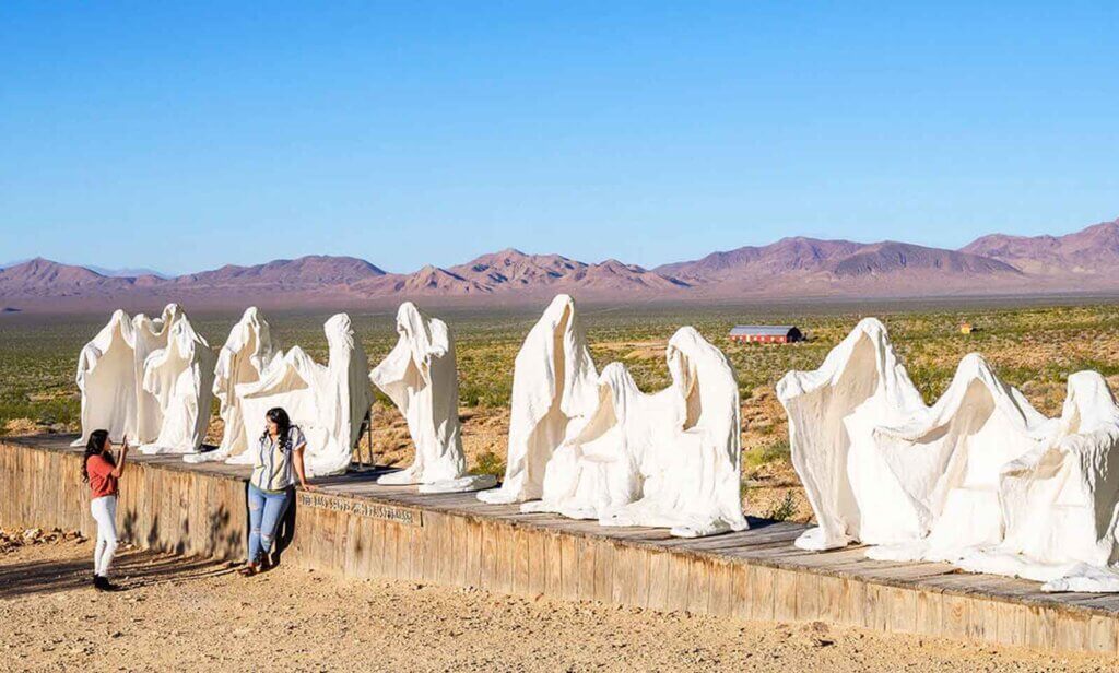 friends taking pictures by ghost scultures at rhyolite