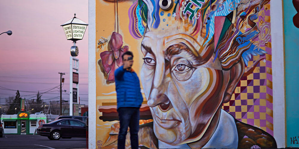 man taking a selfie by mural titled georgia on my mind mural by joe c rock
