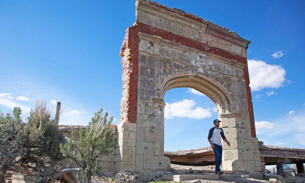 man walking through archway at metropolis ghost town