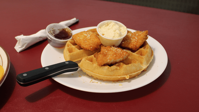 A plate from Strawberry Hill Diner shows chicken and waffles plate, complete with butter and syrup on the side.