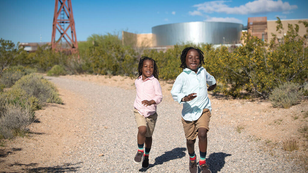 two boys running on trails at the springs preserve las vegas