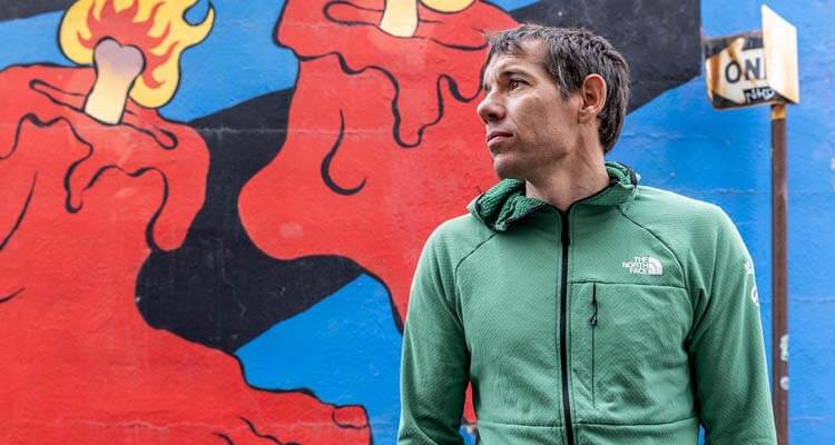 alex honnold posing by mural in elko