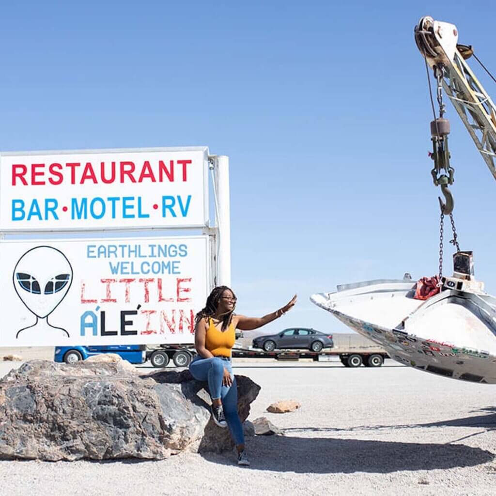woman posing by ufo and little ale inn sign