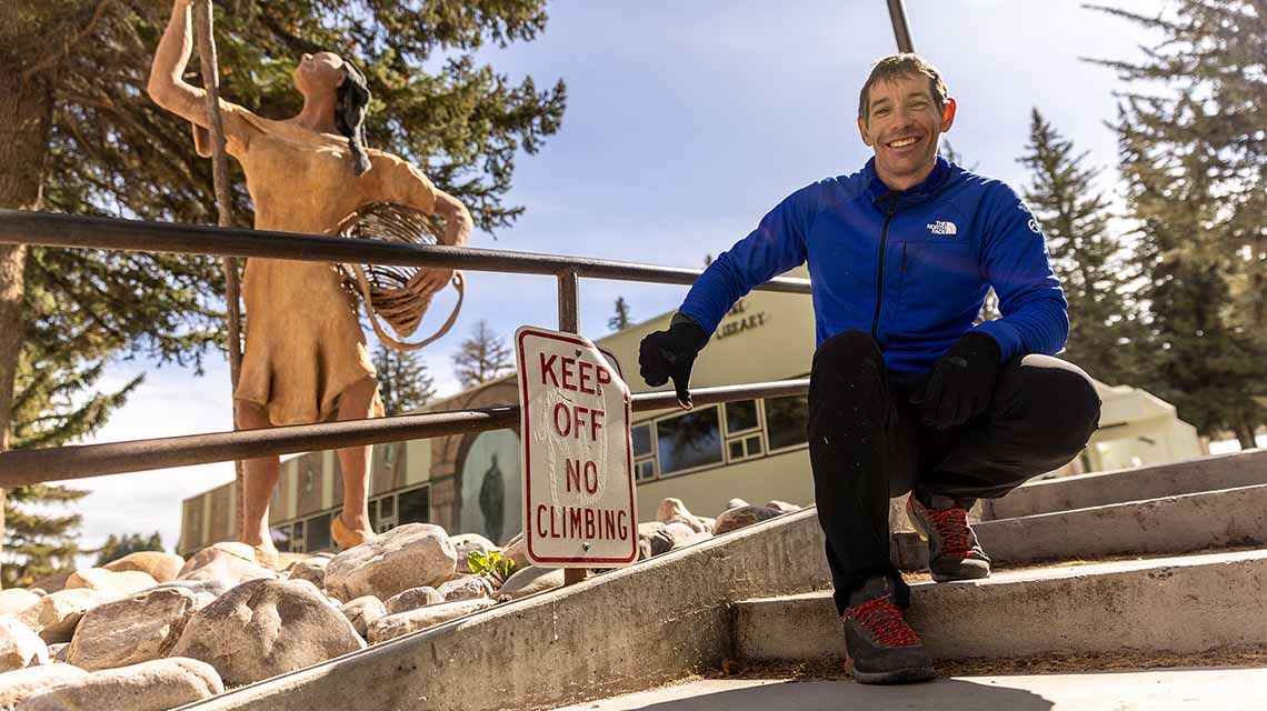 alex honnold posing by no climbing sign