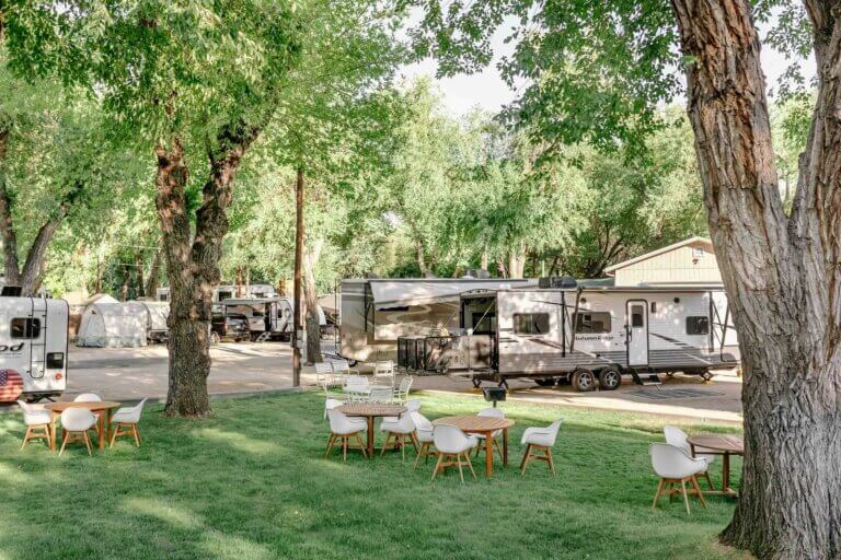 Tables located on a lawn in front of RVs at River West Resort in Reno.
