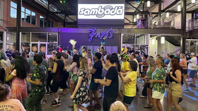 A group of people gather on the dance floor at Reno Public Market.