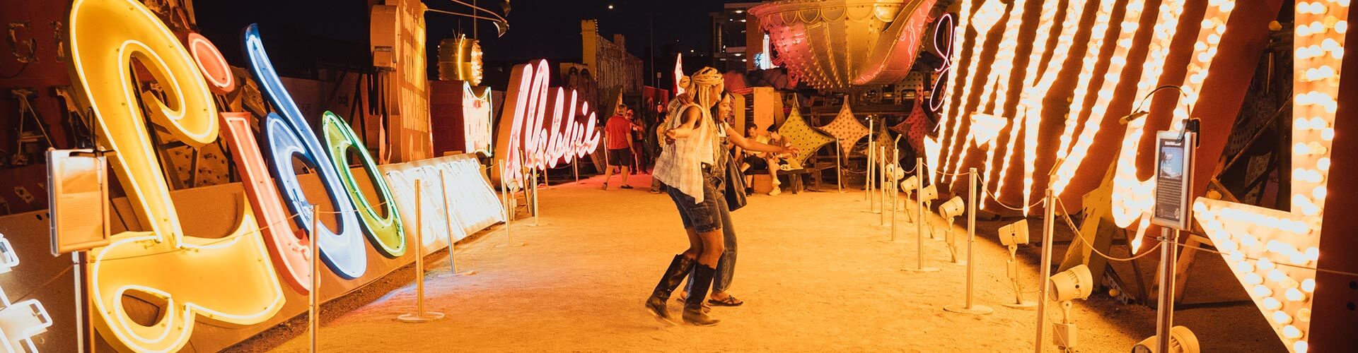 two women on a neon boneyard tour at the neon museum in las vegas nevada