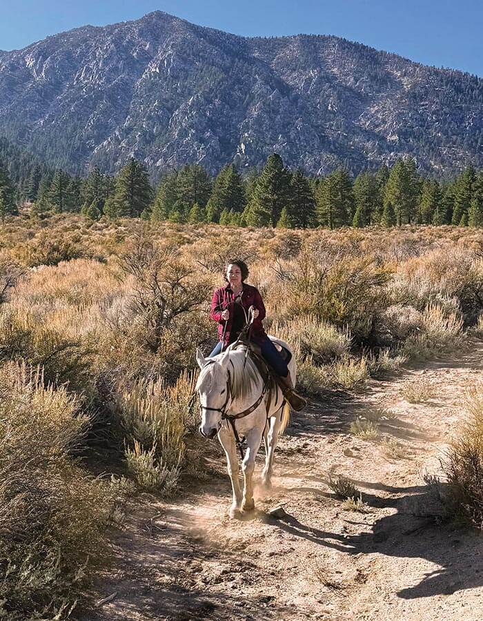 a woman riding a horse with bader ranch trail co in gardnerville nevada