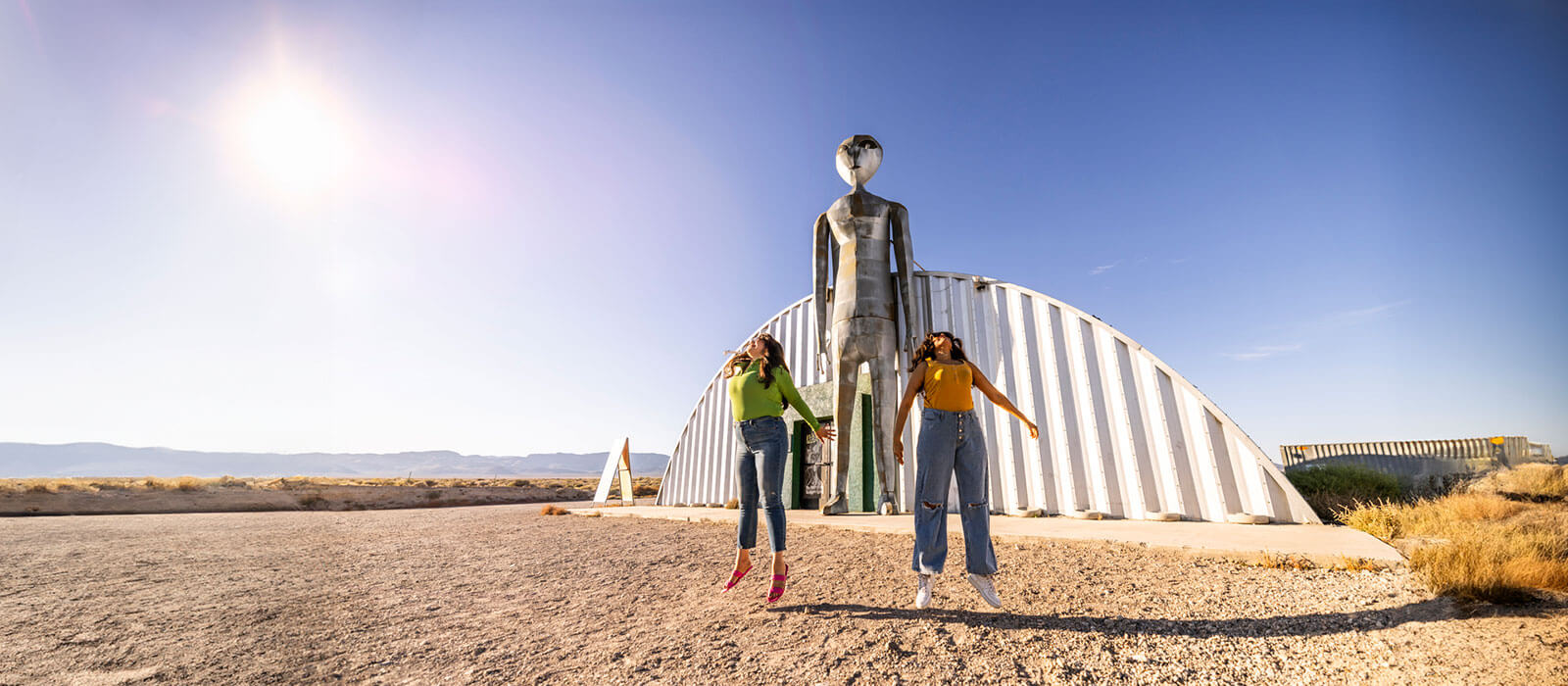 two women jumping outside the alien research center in hiko nevada on the extraterrestrial highway